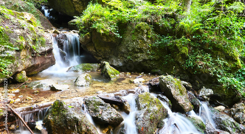 Mountain river with green mossy stones and small waterfall. Captured in Prosiecka Dolina, Slovak Natural Park in Slovakia. Long exposure. photo