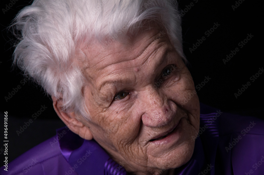 Portrait of an aged woman looking away on a black background Portrait of an aged woman looking away on a black background