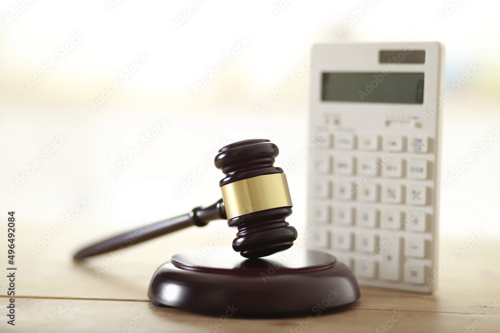 Wooden judge's gavel and calculator on table - obrazy, fototapety, plakaty 