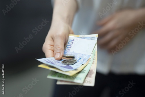Woman holding cash and coins