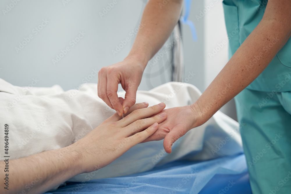 Obraz premium Neurologist using needle for examining male patient