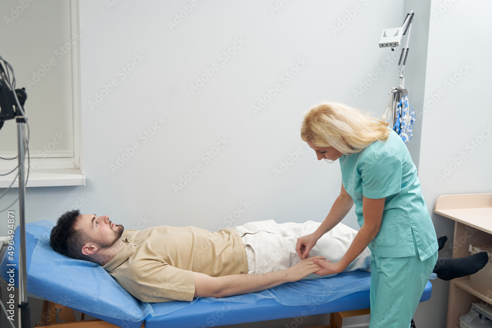 Fototapeta premium Young calm man lying in neurologist office