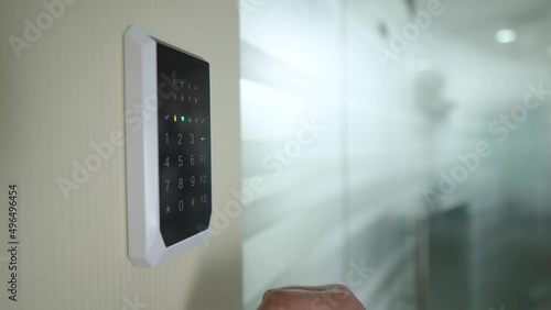 Turn off smart security system in the room using the keyboard on the wall. Modern technologies in everyday life. Pressing the touch buttons on the device. High-tech