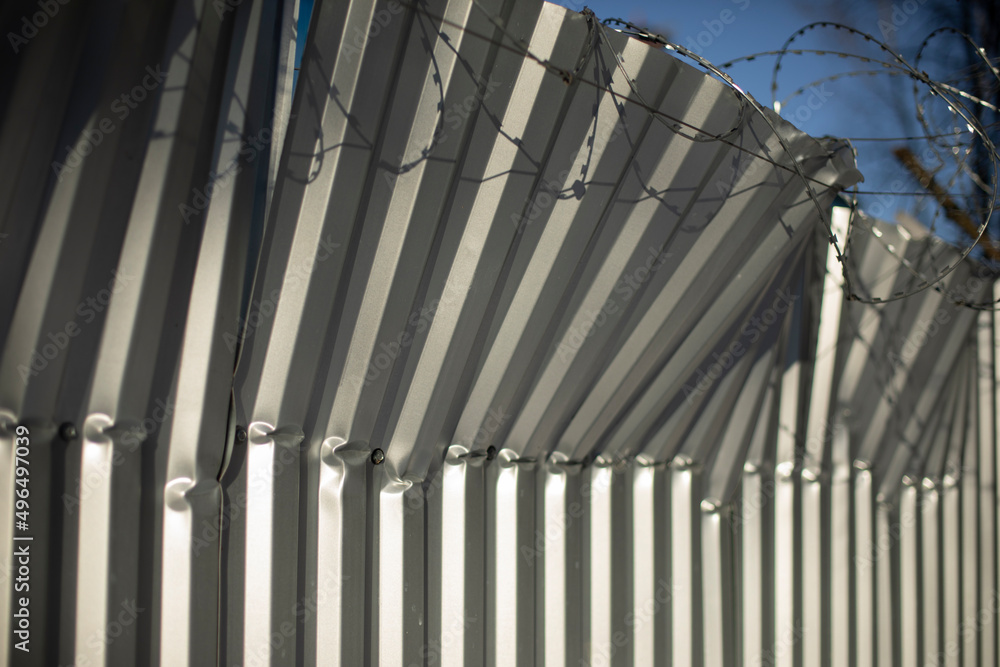 Broken fence. Fence from profile sheet bent. Rumpled iron. Broken fence. Fence from profile sheet bent. Rumpled iron.