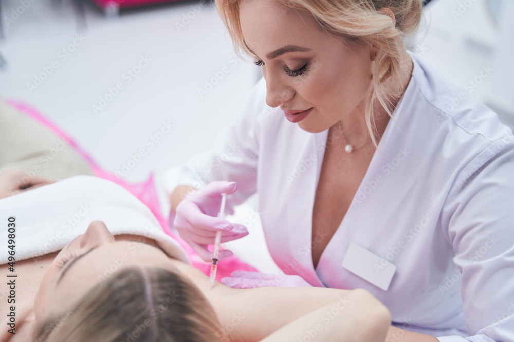 Obraz premium Concentrated dermatologist treating female patient for hyperhidrosis