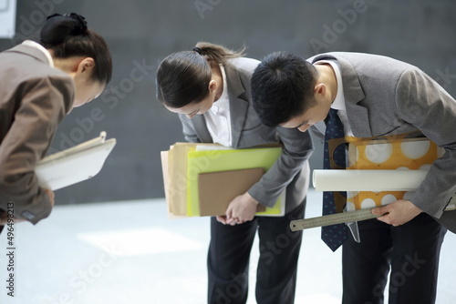 Business people taking bow in corridor