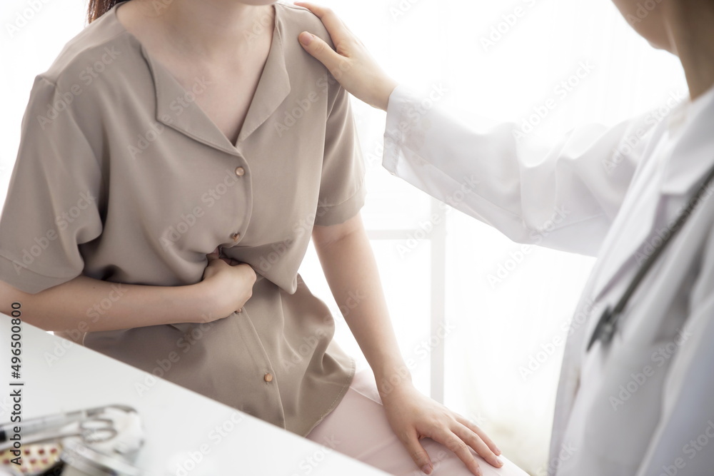 Doctor checking patient's stomachache in office