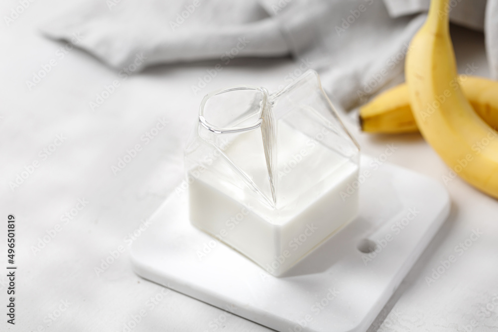 Milk in glass jar with banana. Milk in the modern milk jug. Sunshine. Milk in glass jar with banana. Milk in the modern milk jug. Sunshine.