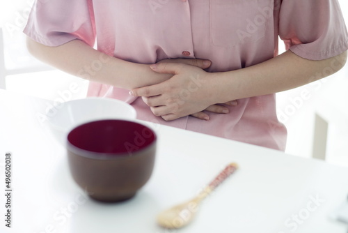 Woman suffering from stomachache on breakfast table