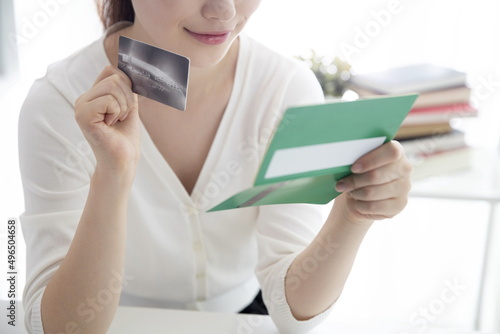 Young woman holding credit card with bank book photo