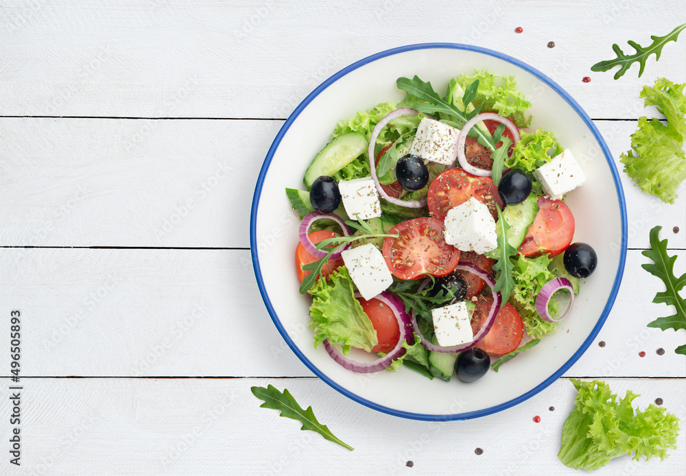 greek salad on white wooden background