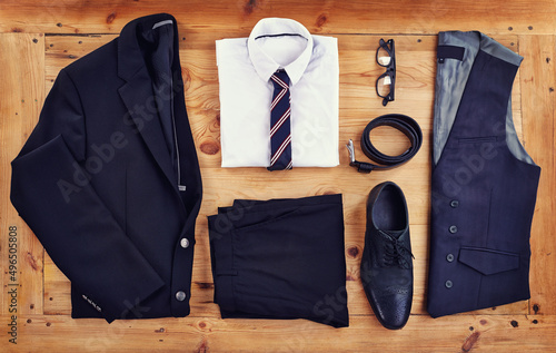 Stand out in the workplace with this stylish outfit. High angle shot of a stylish business outfit laid out on a wooden table.