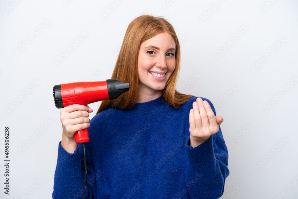 Young redhead woman holding a hairdryer isolated on white background inviting to come with hand. Happy that you came Young redhead woman holding a hairdryer isolated on white background inviting to come with hand. Happy that you came