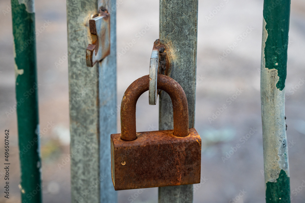 Rusty lock on the gate of a small gray container close-up. Rusty lock on the gate of a small gray container close-up.