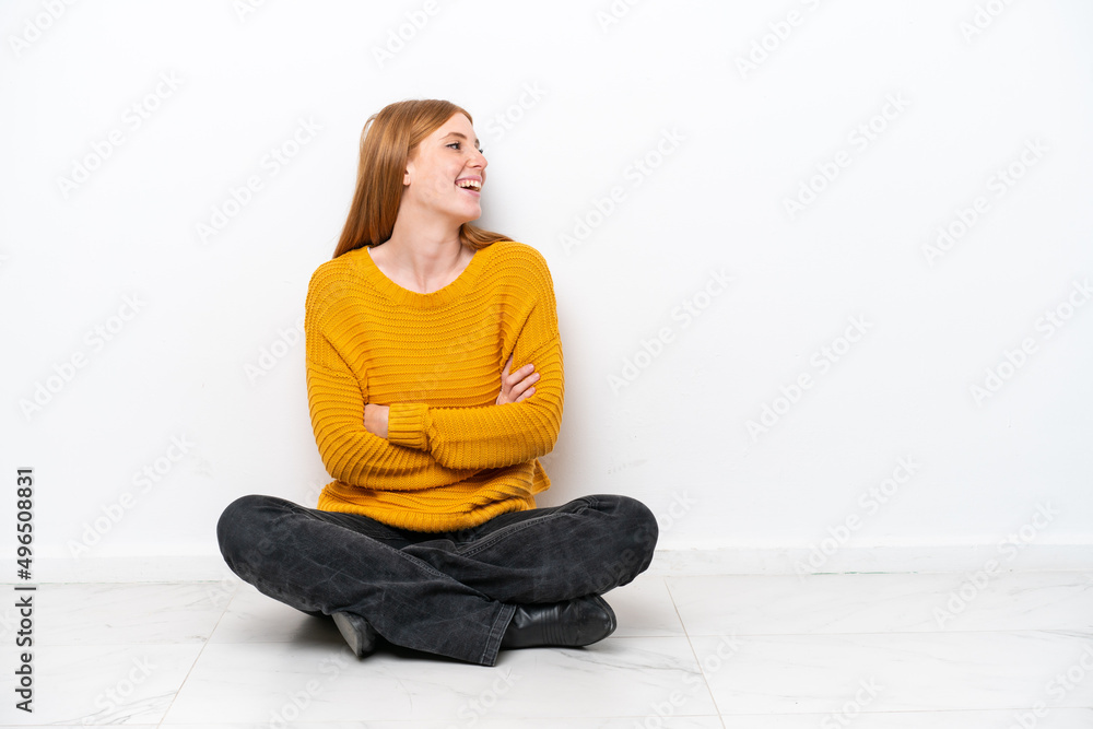 Young redhead woman sitting on the floor isolated on white background happy and smiling Young redhead woman sitting on the floor isolated on white background happy and smiling