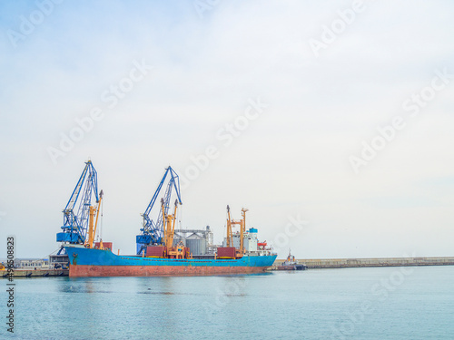 Dry cargo ship in port. Vessel loading. Harbor cranes loading Grain. Food shortage 2022 
