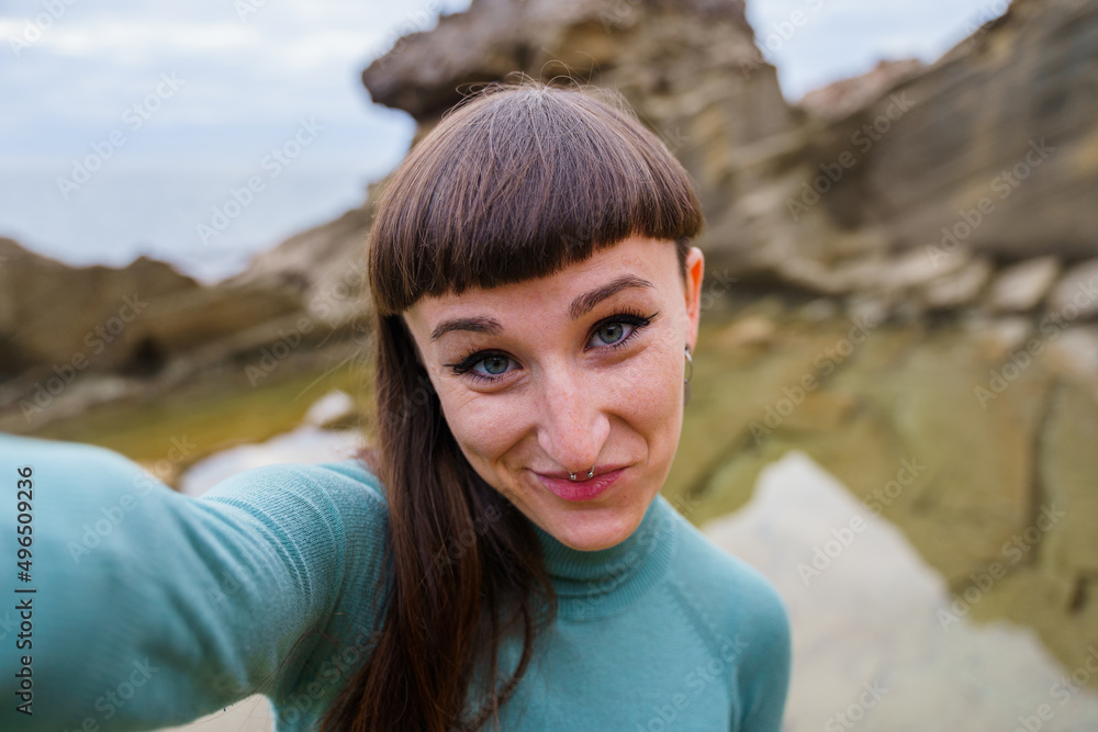 Happy woman smiling and taking a photo by the sea Happy woman smiling and taking a photo by the sea