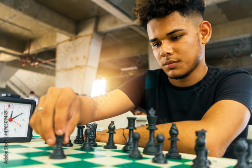 Latin young man practicing chess techniques in a basement. Concept of intellectual development in the millennial youth of Nicaragua, Central America and South America.