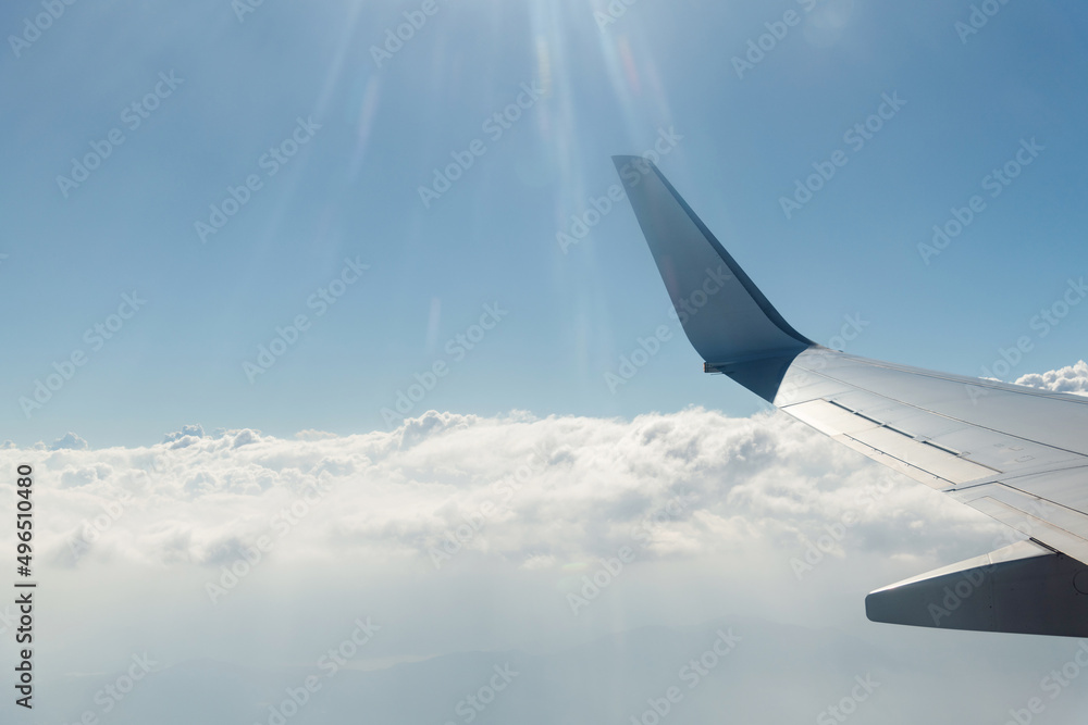 Wing of airplane flying above clouds Wing of airplane flying above clouds