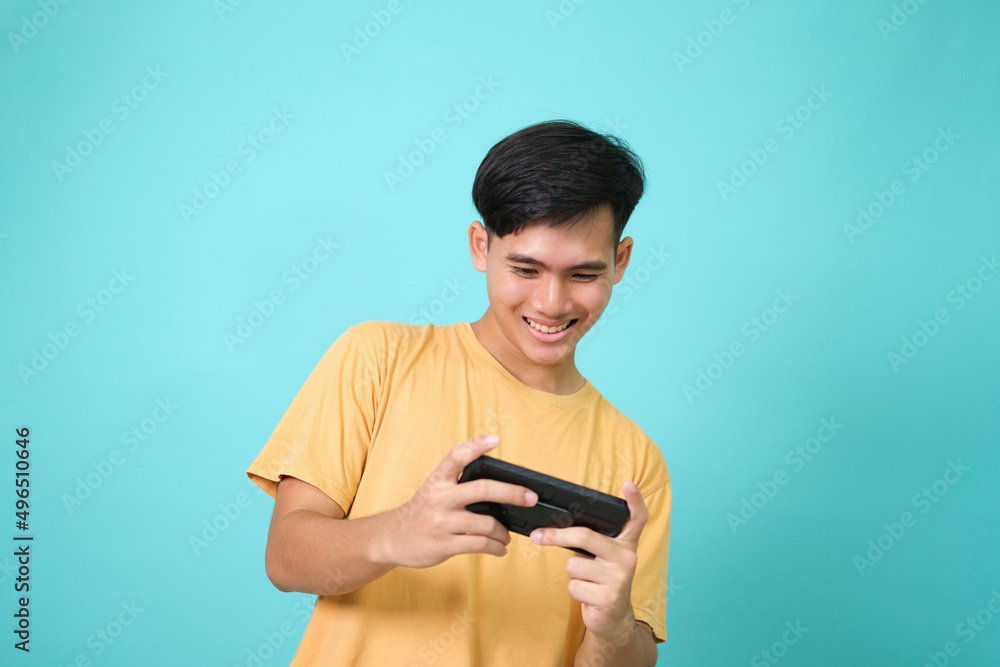 Young man using mobile phone playing online game Young man using mobile phone playing online game