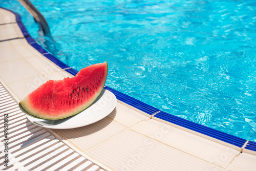 Watermelon slice near the pool in summer day