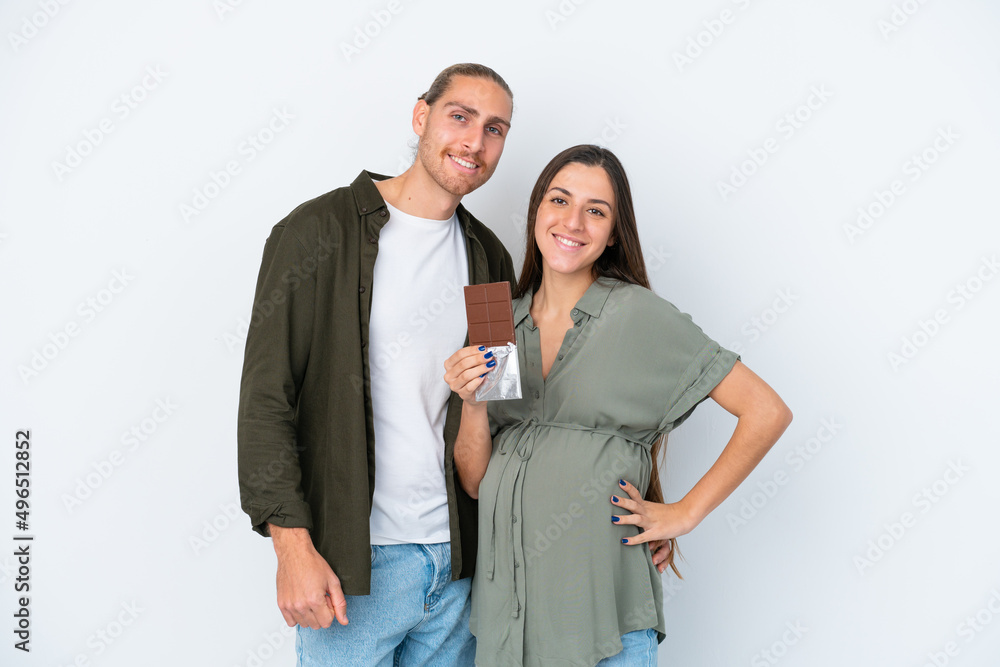 Young caucasian couple isolated on white background pregnant and holding chocolate Young caucasian couple isolated on white background pregnant and holding chocolate