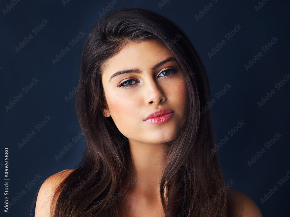Naklejka premium Shes the picture of beauty. Cropped portrait of a gorgeous young woman posing against a dark background.
