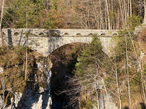 Old stone bridge over the river Löntsch and over the canyon Löntschtobel at the foot of the alpine reservoir Klöntalersee (or Kloentalersee) - Canton of Glarus, Switzerland (Schweiz)