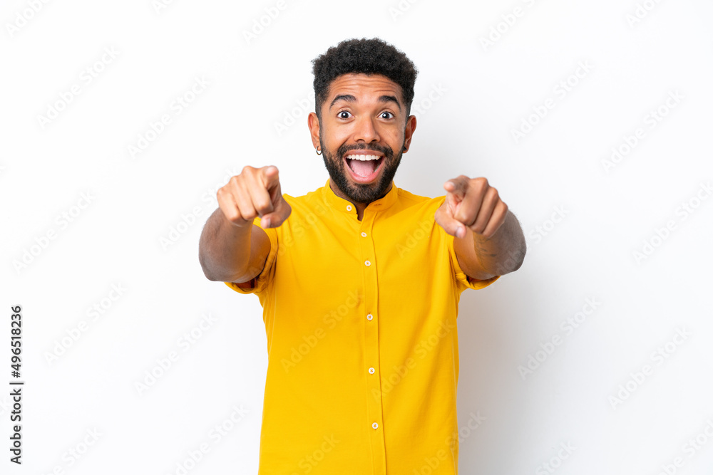Young Brazilian man isolated on white background surprised and pointing front Young Brazilian man isolated on white background surprised and pointing front