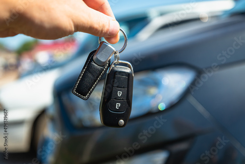The keys to the SUV in the hand, in the background is the car. Sale, purchase of cars.