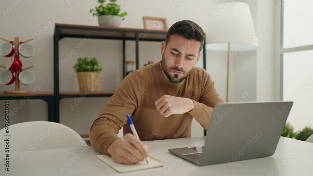 Young hispanic man concentrate sitting on table studying at home Young hispanic man concentrate sitting on table studying at home