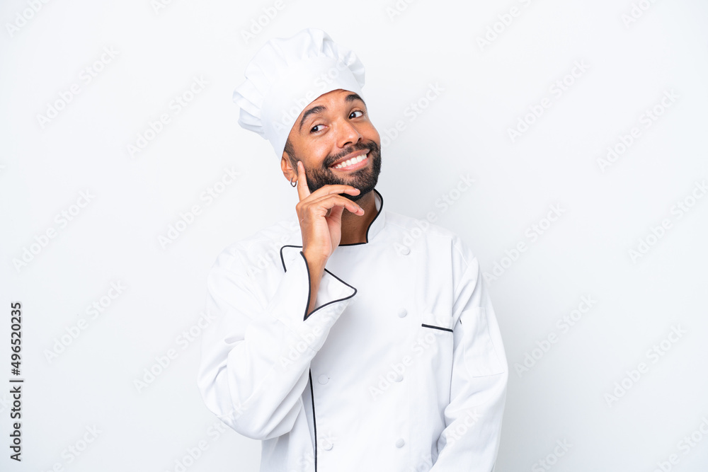 Young Brazilian chef man isolated on white background thinking an idea while looking up Young Brazilian chef man isolated on white background thinking an idea while looking up
