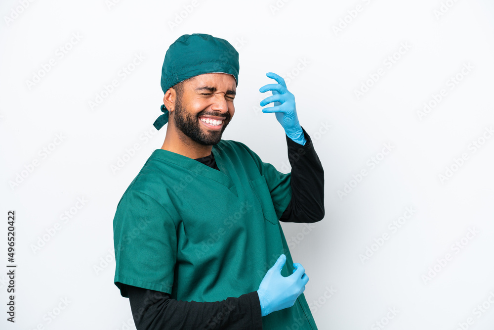 Surgeon Brazilian man in green uniform isolated on white background making guitar gesture Surgeon Brazilian man in green uniform isolated on white background making guitar gesture
