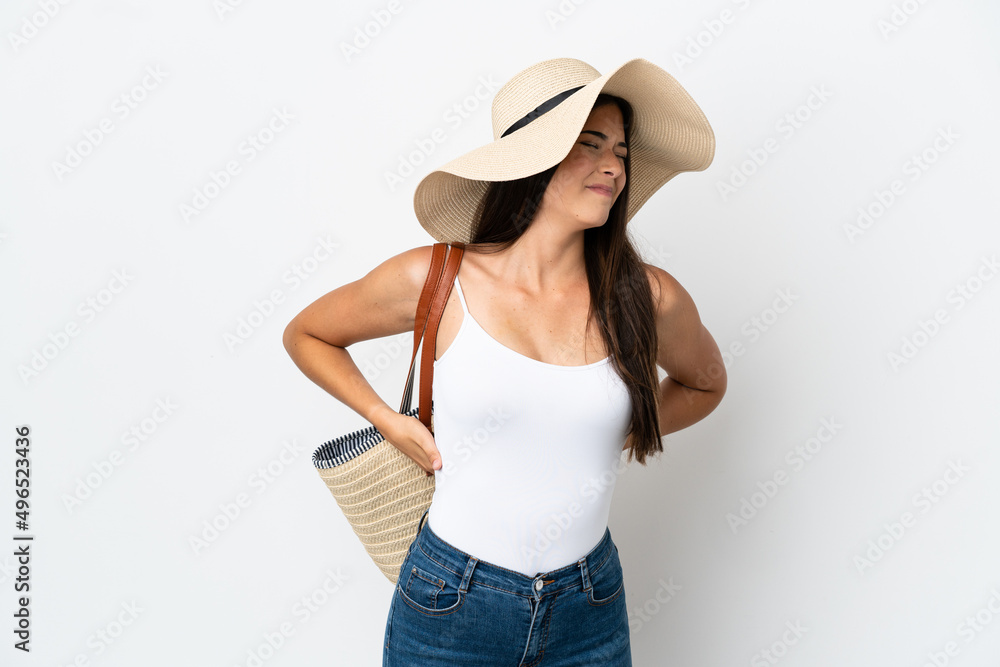 Young Brazilian woman with Pamela holding a beach bag isolated on white background suffering from backache for having made an effort Young Brazilian woman with Pamela holding a beach bag isolated on white background suffering from backache for having made an effort