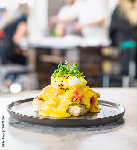 Tableau sur toile Crispy toast with salmon, poached egg, mashed avocado and hollandaise sauce with micro green