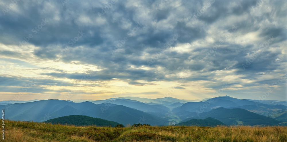 Panorama from the top of Mount Bozova in Transcarpathia, Ukraine. Summer evening in the Carpathian mountains. Beautiful cloudy sky over the villages of the valley
