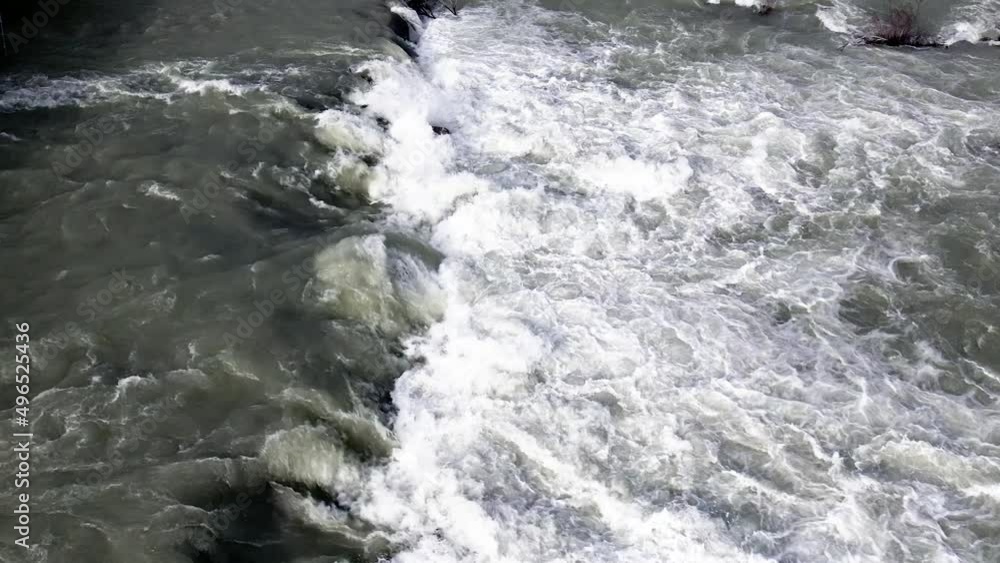Slow motion aerial view of spring high water rushing down the river. River rapids aerial view Slow motion aerial view of spring high water rushing down the river. River rapids aerial view