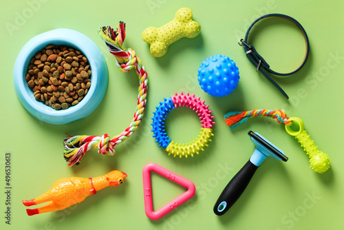 Pet accessories, bowl of dry feed, toys. Top view, flat lay. photo