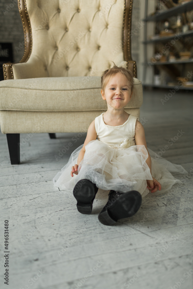 little girl looks like a princess, laughs on the floor