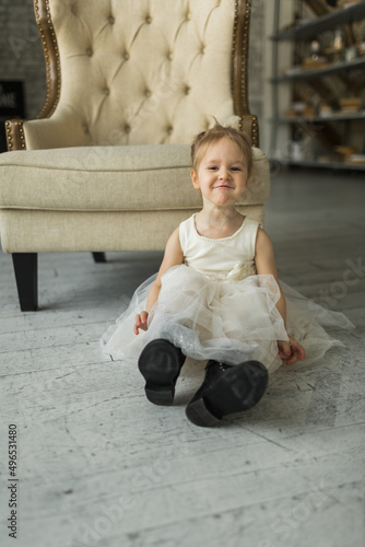 Obraz na płótnie little girl looks like a princess, laughs on the floor w salonie