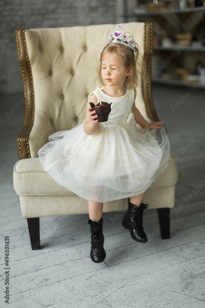 young princess celebrates her birthday. blows out the candle on the cake