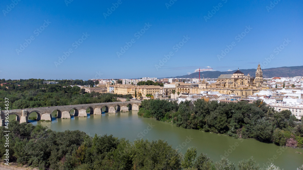 Aerial view of the old medieval city of Cordoba in Andalusia, Spain during a sunny day. Medieval mosque cathedral and Roman bridge over Guadalquivir river, UNESCO World Heritage site. Tourism.
