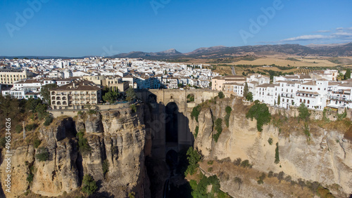 Aerial drone view of The Puente Nuevo, New Bridge in Ronda. White villages in the province of Malaga, Andalusia, Spain. Beautiful village on the cliff of the mountain. Touristic destination. Holidays.