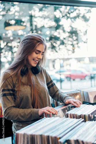 Woman choosing vinyl record in music record shop