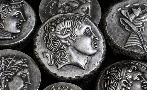 Ancient Greek coins close-up, portrait of Alexander the Great in center. Pattern of old vintage silver money. Texture, collection and background theme.  photo