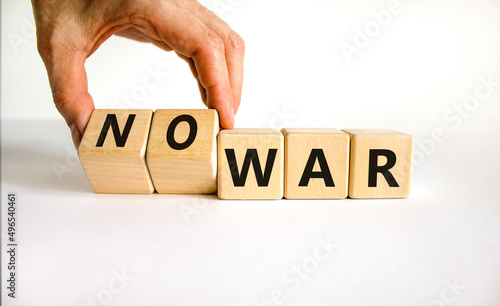 No war symbol. Businessman turns cubes and changes concept words War to No war. Beautiful white table white background. Business and no war concept. Copy space.