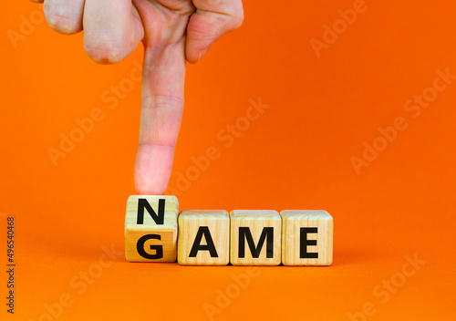 Name of the game symbol. Wooden blocks with concept words Name Game. Businessman hand. Beautiful orange table orange background. Business and name of the game concept. Copy space.