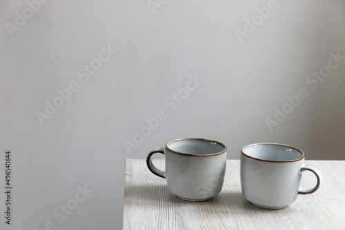 Two porcelain light blue cups are on the table