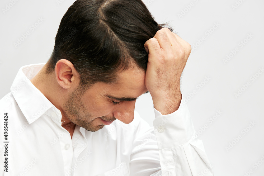 handsome man holding his head in white shirts hand gesture copy-space light background handsome man holding his head in white shirts hand gesture copy-space light background
