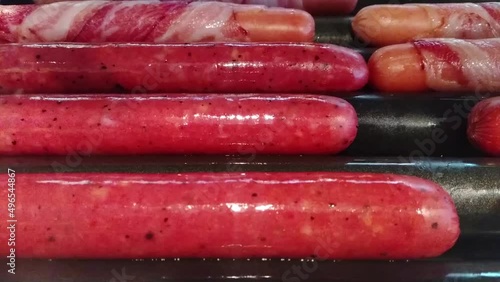 sausages cooking on an automatic electro barbecue grill